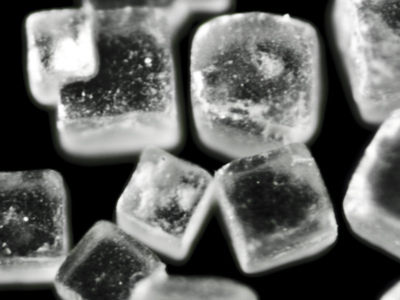 La vista magnificada de los cristales de sal muestra estructuras cúbicas blancas claras.