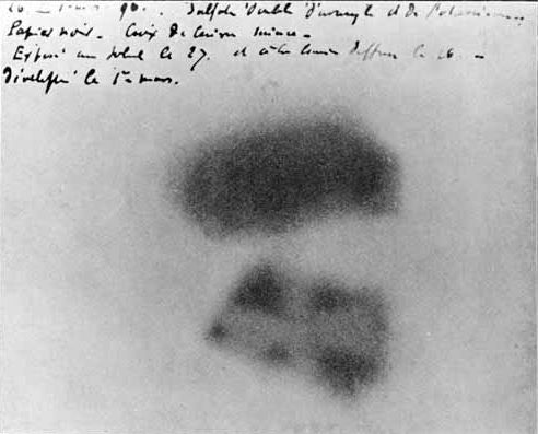 Black and white picture of a photographic film with two areas of dark spots. One is rectangular in shape and the other has an imprint of a Maltese Cross. 