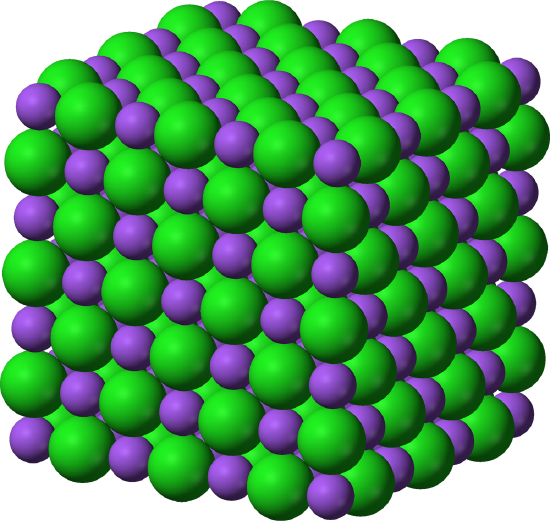 A three dimensional cubic structure is made up of an alternating pattern of green and purple spheres. The green sphere is slightly larger than the purple sphere. 