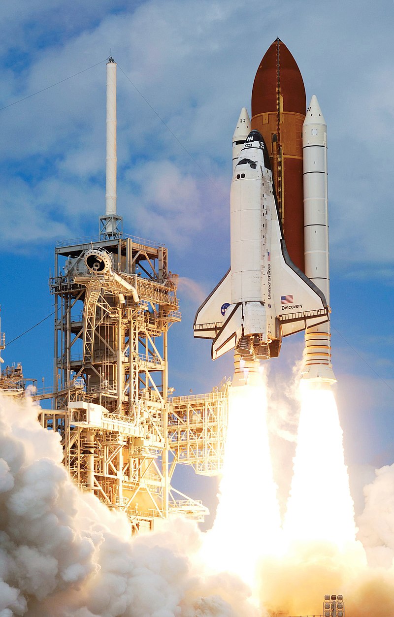 American space shuttle is shown with the rockets blasting it upward as it launches.