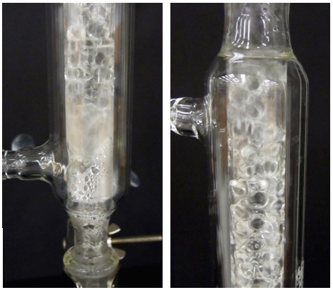  Closeup of fractionating column with extensive liquid pooling on the beads and sides of column.