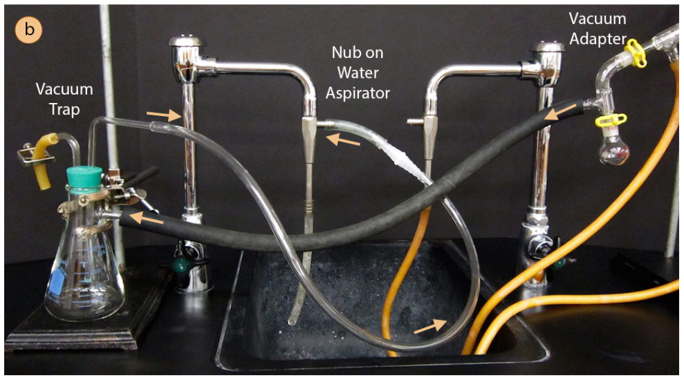 Vacuum hose of distillation apparatus attached to vacuum trap flask. A water tube attached to a faucet connects to the vacuum trap.