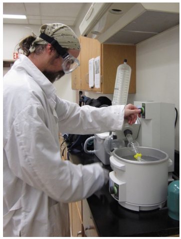  Student in lab coat using a rotary evaporator.