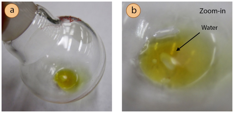  A: Closeup of receiving flask, showing small pool of clear water in yellow distillate. B: Figure 5.73A with additional zoom.