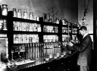 Foto antigua en blanco y negro de químico analítico trabajando