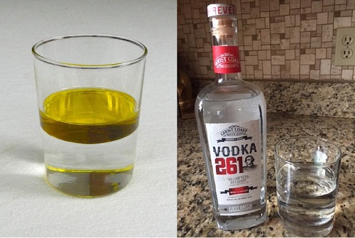 A glass has a layer of water with a layer of oil floating on top of it, completely unmixed. Next to that photo is a photo of a bottle of vodka.