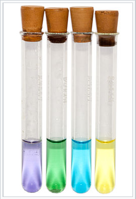 Four test tubes. From left to right, lilac liquid, green liquid, blue liquid, yellow liquid.