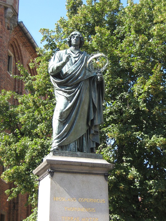 Image of a statue of Astronomer Nicolaus Copernicus holding model of Heliocentric Solar System.