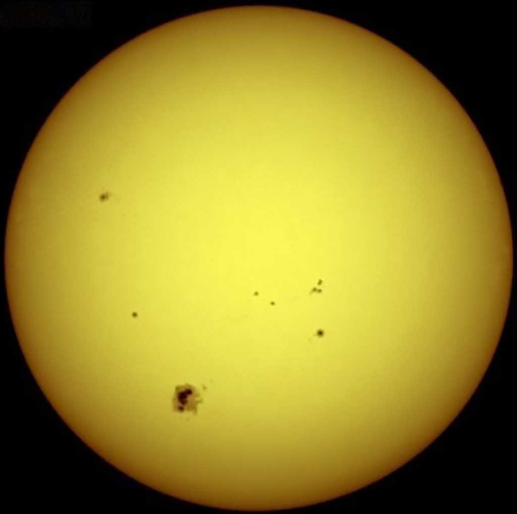 Image of the Sun with some sunspots visible. The two small spots in the middle have about the same diameter as our planet Earth.