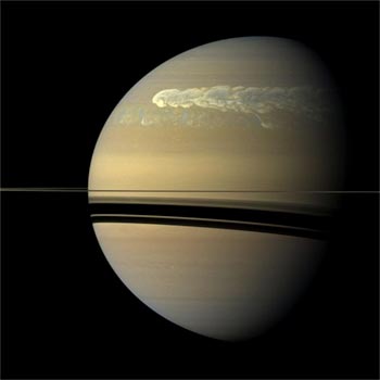 Image Storm on Saturn’s Cloud Tops; the rings appear as a thin line, with the shadow of the rings below the rings on the planet.