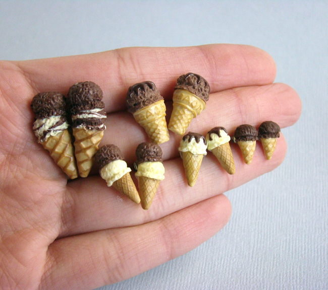 Photo of a hand that's holding five pairs of "ice-cream cone earrings," each pair smaller than the next.