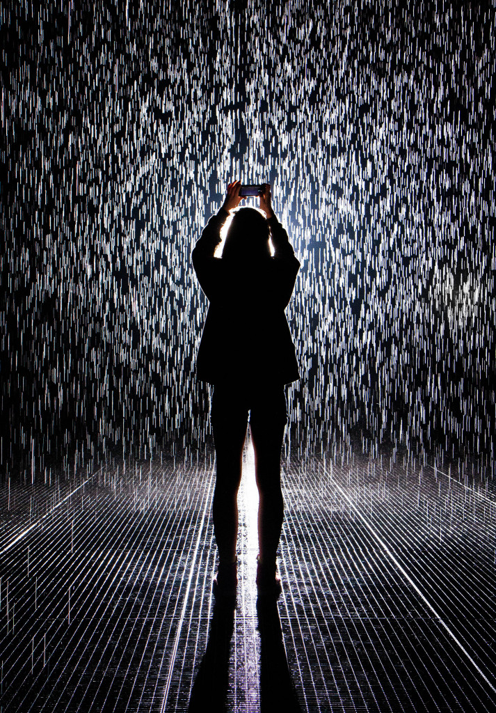 Photo of a woman in silhouette staring upward in the MoMA rain room.