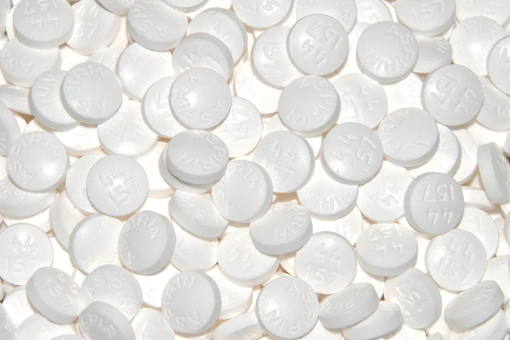 Photo of several dozen aspirin tablets