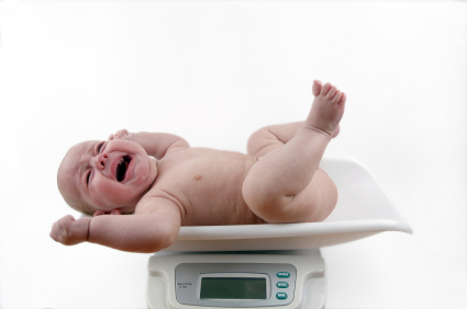 A baby being weighed on a digital scale