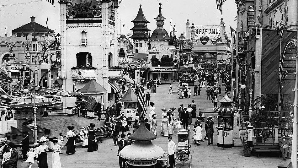 Photograph of Luna Park on Coney Island showing decorative buildings , street vendors, and people.