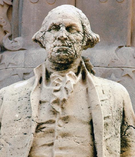 A statue with damage on the face from acid rain.