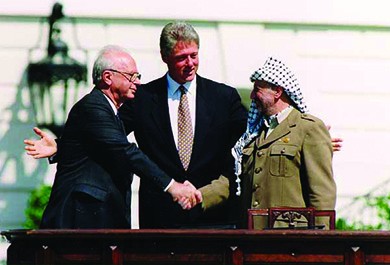 A photograph shows Yitzhak Rabin and Yasser Arafat shaking hands. Bill Clinton stands between them with his arms open in a welcoming gesture.