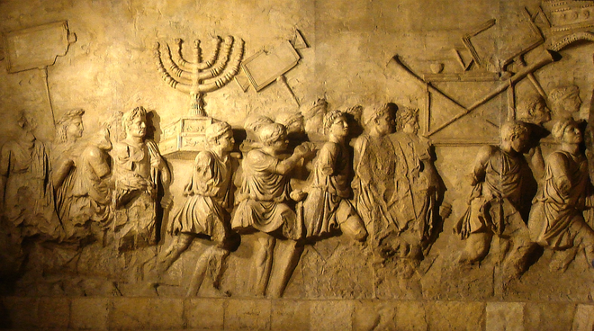 A stone relief showing Roman soldiers carrying treasure from the sack of Jerusalem, including a menorah.