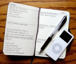 Open day planner with pen and iPod