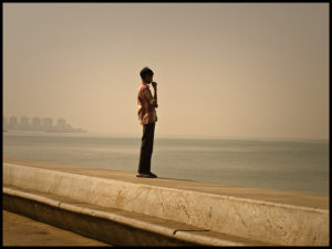 Young man standing in profile on a sea wall
