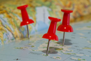 Three red push-pins noting islands on a map