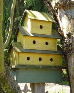 yellow birdhouse with three levels