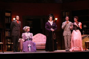 Five actors in period dress on stage in a living room scene