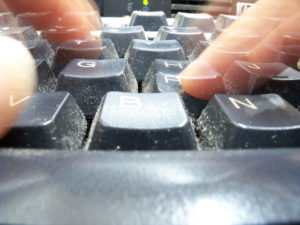 Close up of computer keyboard with blurry fingers