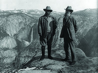 A photograph shows Theodore Roosevelt and John Muir standing atop a precipice in Yosemite National Park.
