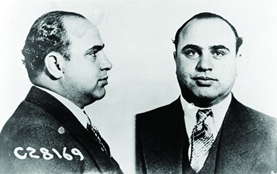 A mug shot shows front and side views of Al Capone.