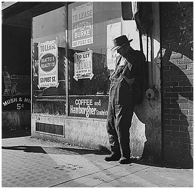 A photograph shows an elderly destitute man leaning against a vacant storefront in San Francisco, California. The window is covered with signs indicating various properties that are “to lease.”