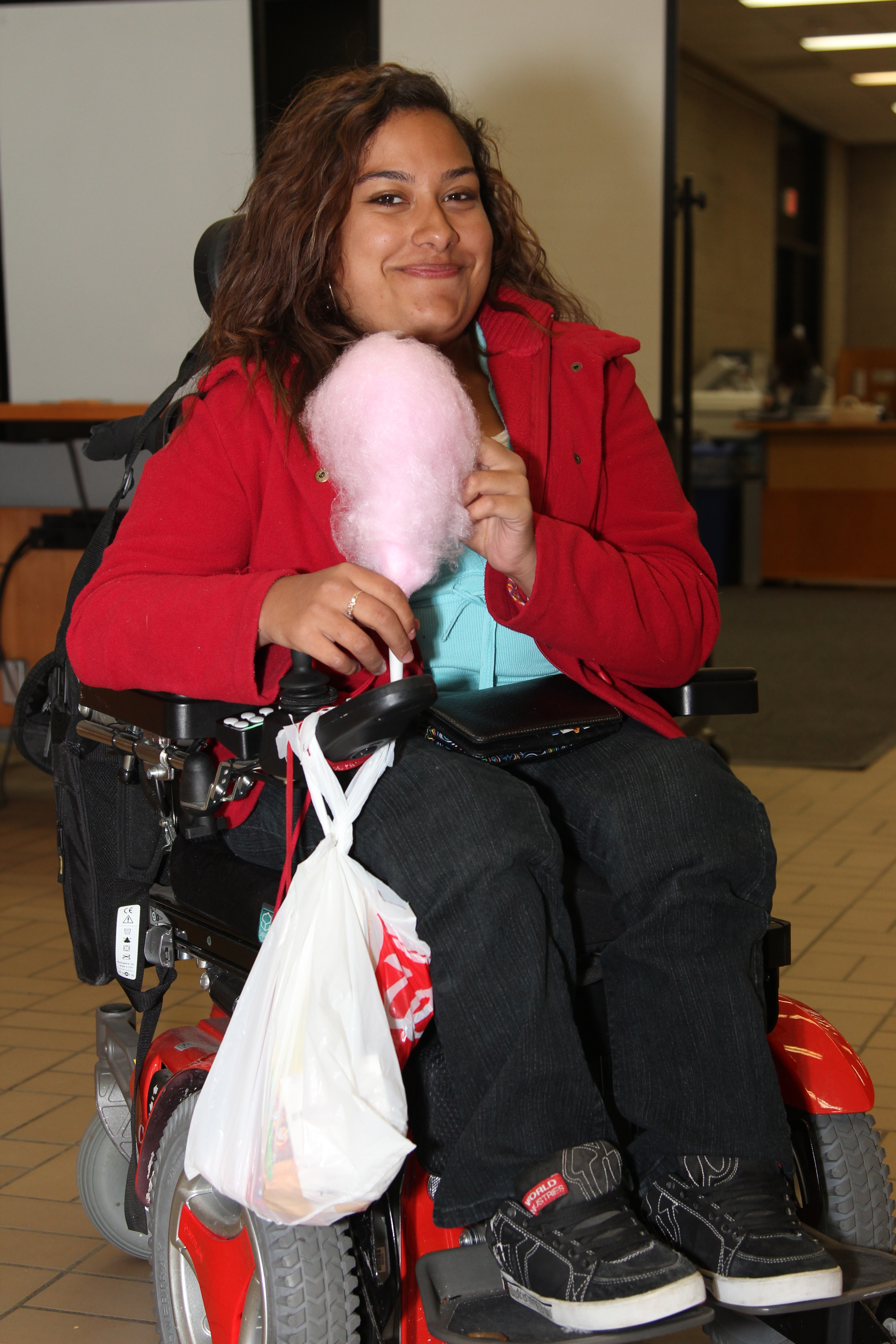 An individual on wheelchair holding cotton candy