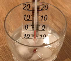 An image of a glass of ice water with a thermometer in it reading 0 degrees Celsius. 
