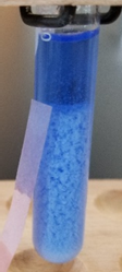 Solución de complejo de cobre amoniaco de color azul con suspensión de precipitado de hidróxido de bismuto blanco.