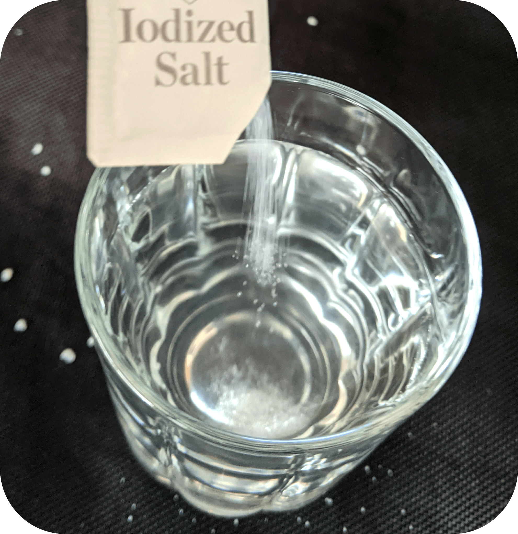 Sal yodada mezclada con agua en una taza de vidrio.