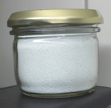 Tarro de polvo blanco, etiquetado como sulfato de cobre anhidro.