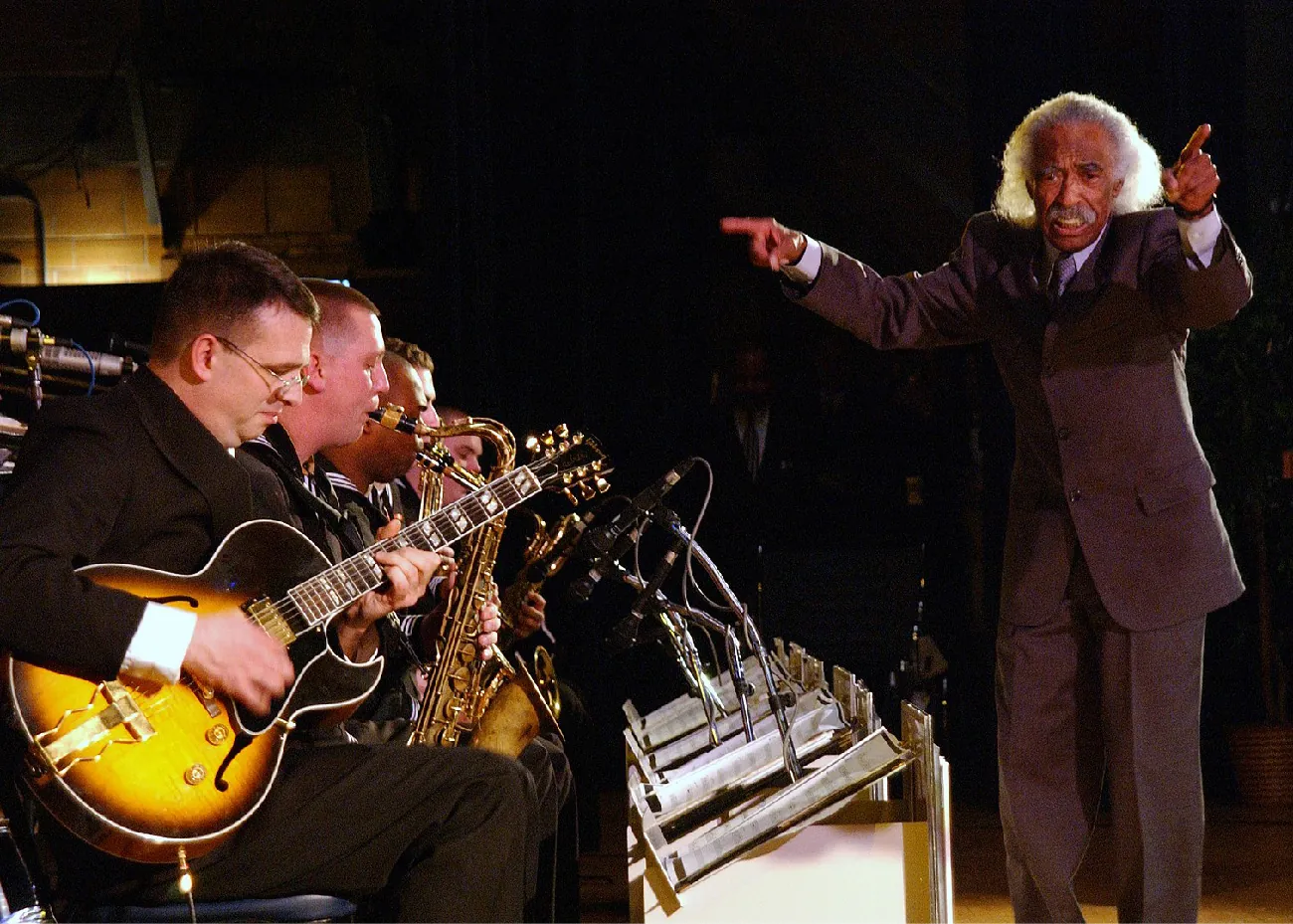 The photo of a conductor leading a group of musicians.