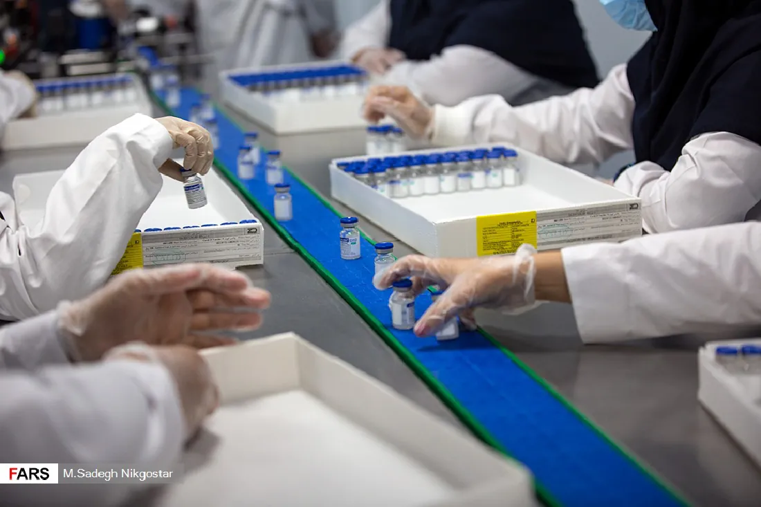 A photo of a group of scientists processing vials of vaccine.