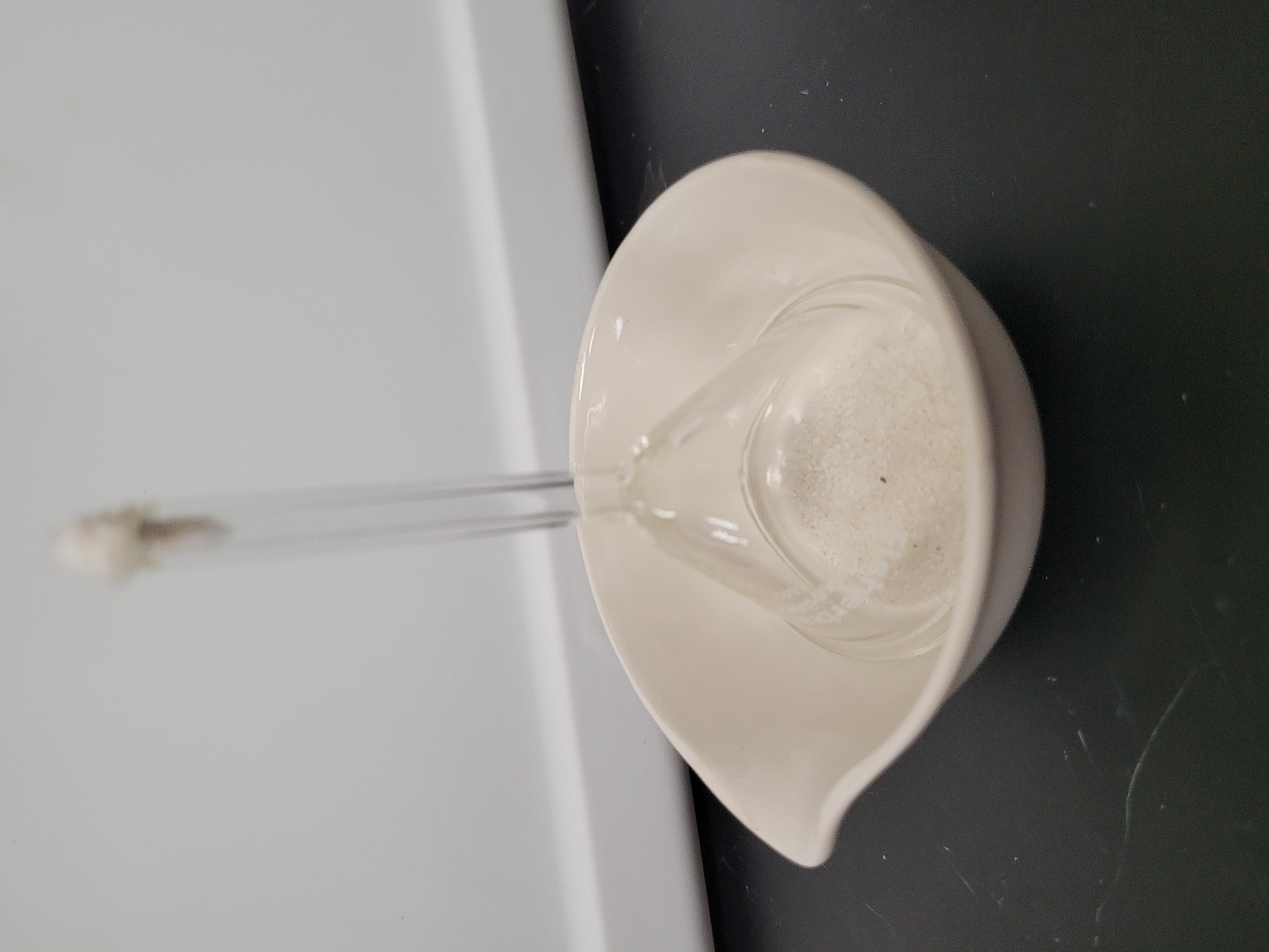 A glass funnel with white powder