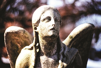 Se muestra una fotografía de una estatua de ángel. Si bien algunos detalles de la estatua, incluidos los rasgos faciales, están presentes, los efectos de la intemperie parecen estar disminuyendo estos rasgos.