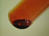 Image of a glass tube filled with bromine liquid.
