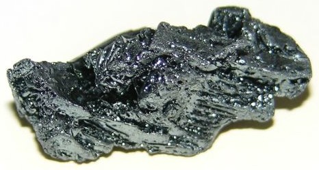 Un pedazo de estructura cristalina con un profundo tinte verdoso oscuro.