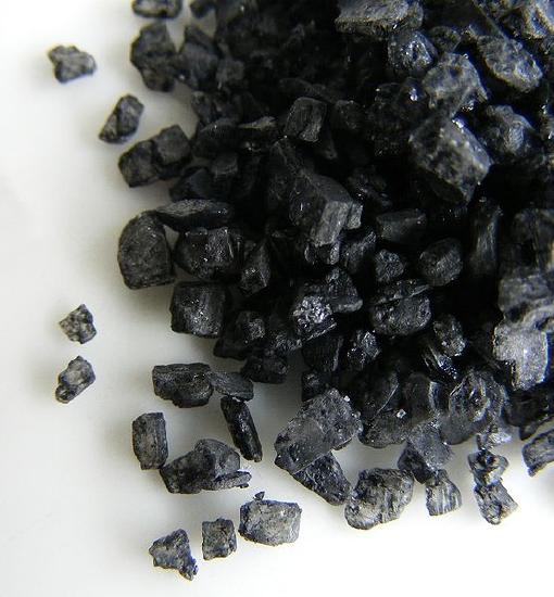 Closeup picture of little black salt crystals. 