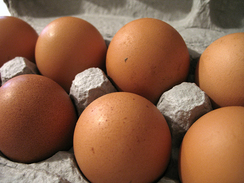 6 huevos grandes en una caja de cartón.