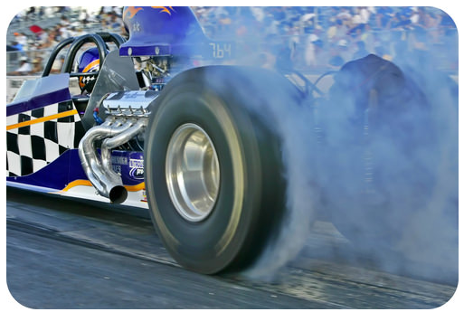 Race Car on race track burning tire, smoke coming from tire.