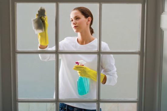 A woman cleaning a glass window.